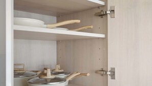 A kitchen with a built-in microwave oven, wooden utensils, and a pot on the countertop. - Modern 1BR Suite Steps to Subway City Views! (Toronto)