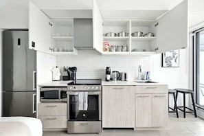 Cocina moderna con horno, microondas y cafetera integrados.