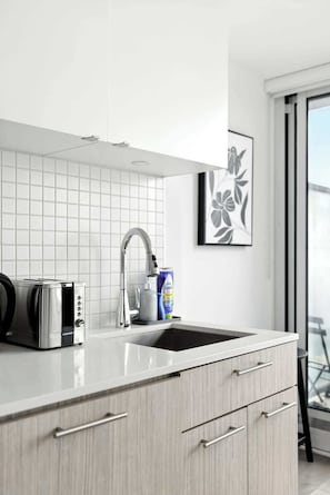 Eine moderne Küche mit eingebautem Toaster, einem Edelstahlarmaturen und einem großen Fenster.