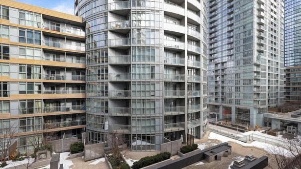 A multi-story residential building with balconies, a courtyard, and a modern architectural design. - Stylish 1BR Lakeside Oasis Patio & Prime Location (Toronto)