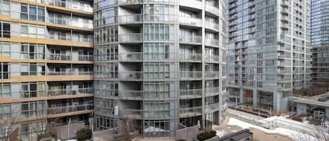 A multi-story residential building with balconies, a courtyard, and a modern architectural design.