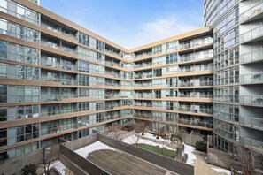 Ein mehrstöckiges Wohngebäude mit Innenhof, Balkonen und einer Fassade aus Glas und Holz.