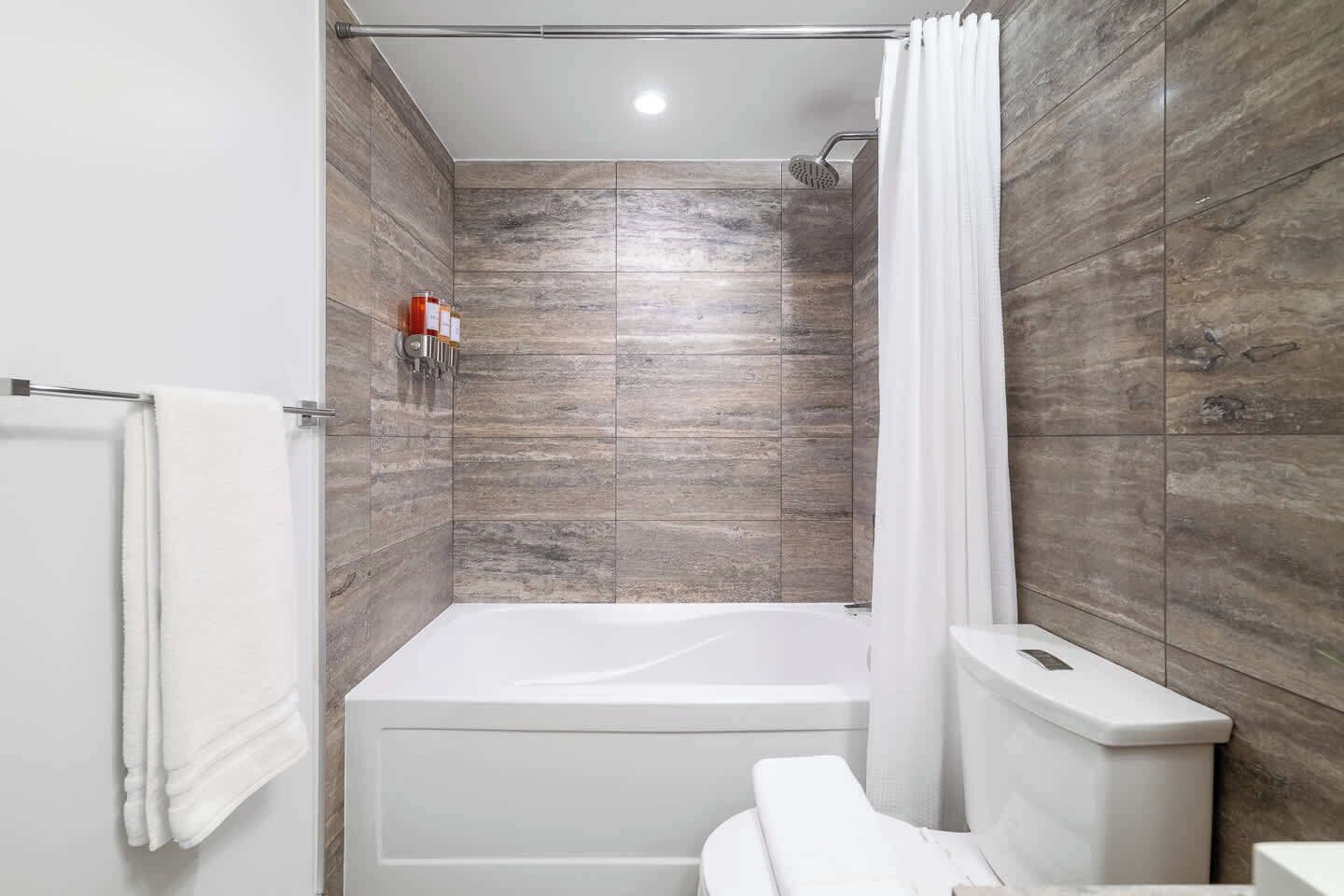 Ein modernes Badezimmer mit Badewanne, Dusche und Toilette.