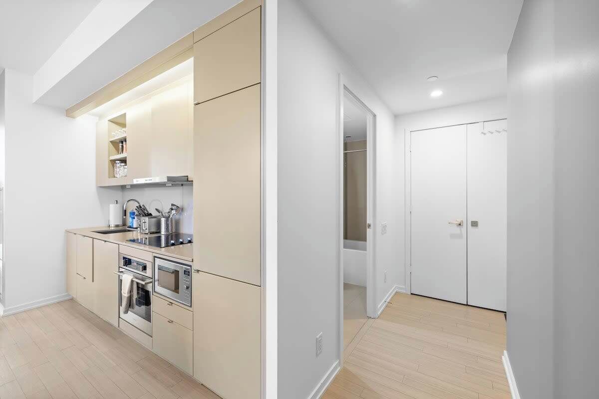 Une cuisine moderne dotée d’appareils électroménagers intégrés, d’un plan de travail et d’un dressing.