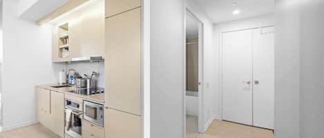 Une cuisine moderne dotée d’appareils électroménagers intégrés, d’un plan de travail et d’un dressing.