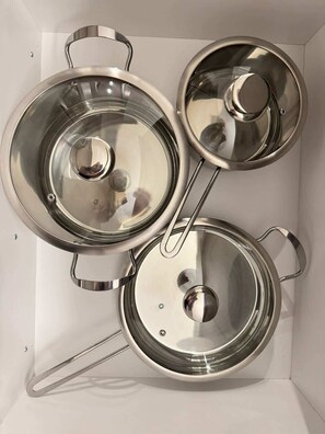 Three stainless steel pots with lids, arranged in a box.