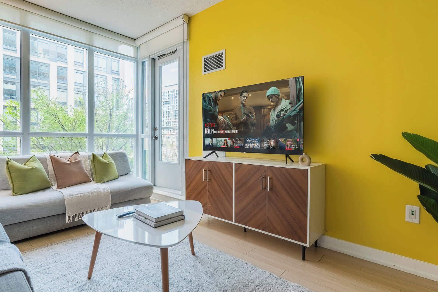 A living room with a sofa, coffee table, and a television on a cabinet.