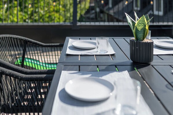 Une table mise pour deux, avec des assiettes, un verre et une plante en pot.