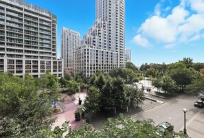 A high-rise residential building with multiple balconies and a pedestrian walkway. - Upscale 2BR Condo Downtown TO Gem w Parking | Parking Available (Toronto)