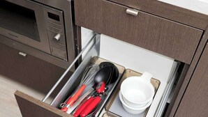 A kitchen drawer with utensils and dishes.
