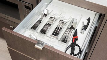 A kitchen drawer with utensils and a canister.