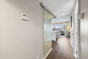Ein modernes Interieur mit Glastrennwand, Küchenbereich und Blick auf eine Stadtlandschaft.