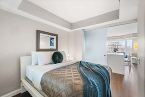 Ein modernes Hotelzimmer mit Bett, Schreibtisch und Blick auf die Stadt.