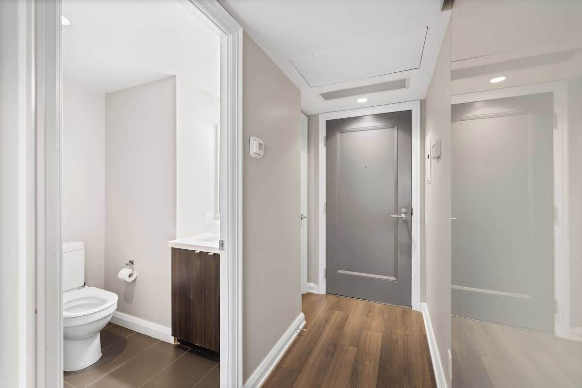 A modern bathroom with a toilet, sink, and shower area.