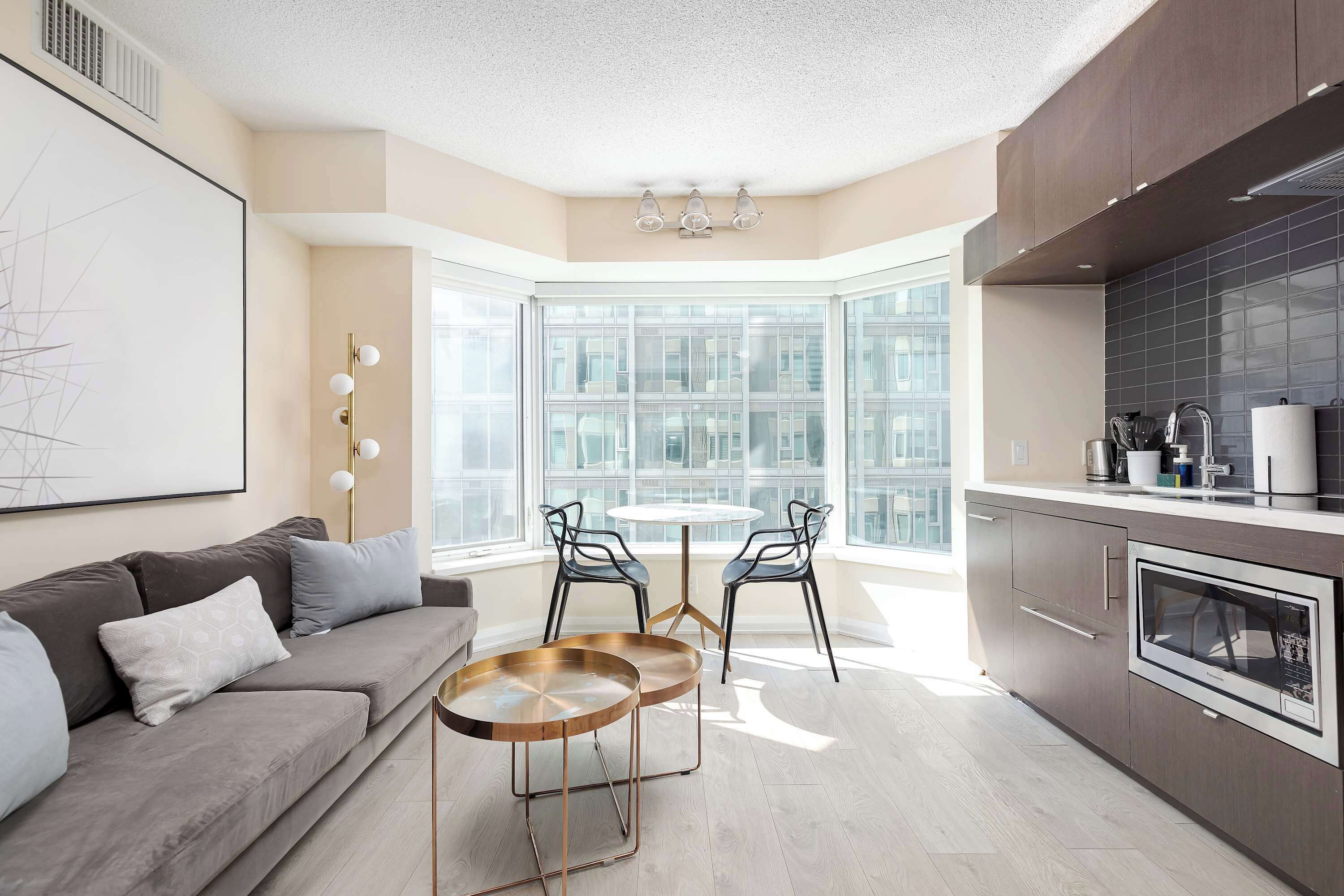 A modern kitchen with a built-in oven and a dining area with a round table and chairs.
