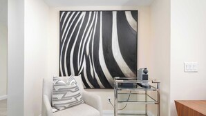 A room with a chair, a zebra-striped pillow, a glass coffee table, and a wall-mounted zebra-striped artwork. - Designer 4 Seasons Luxury Bldg of Yorkville! (Toronto)