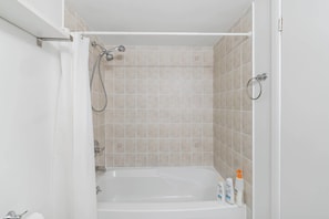 A bathroom with a bathtub, shower, and a towel rack. - Modern Studio by Massey Hall | Heart of Toronto | Parking Available (Toronto)
