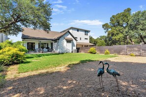 A two-story house with a covered patio, a fenced yard, and two peafowl. - Skier's Cove - Lake Access & Deeded Boat Slip (Granite Shoals)