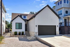 A residential building with a garage, a front entrance with steps, and a driveway. - Skier's Cove - Lake Access & Deeded Boat Slip (Granite Shoals)