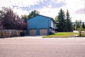 A two-story building with a blue exterior and two garage doors.