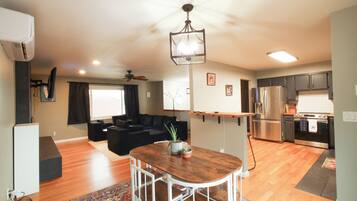 A modern apartment with a living area, kitchen, and dining space.