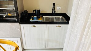 A compact kitchen with a stainless steel sink, a coffee maker, and a kettle on the countertop. - Ravello Elegance Center Foz do Iguaçu (Foz do Iguaçu)