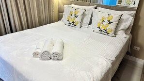 A neatly made bed with white linens and two pillows with floral embroidery. - Ravello Elegance Center Foz do Iguaçu (Foz do Iguaçu)