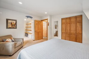 A bedroom with a bed, a sofa, a wardrobe, and a door leading to a hallway. - Golden Getaway w/ EV Charger - 14 min to Red Rocks! (Golden)