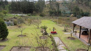 Un jardin agrémenté d’un kiosque, d’une fontaine et de diverses plantes.
