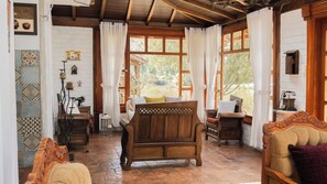 Um quarto rústico com uma cama de madeira, uma cadeira de madeira e uma pequena mesa com um abajur.