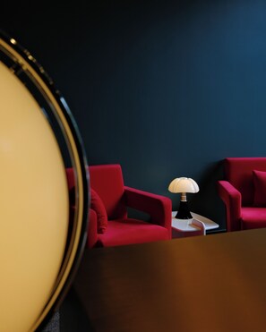 A room with two red chairs, a small white table, and a lamp. - Proza Hotel & Restaurant (Kutaisi)