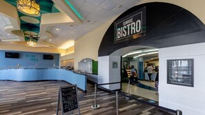 Un bistró moderno con una barra curva, un letrero que dice "SUNRISE BISTRO" y un menú en la pizarra afuera.