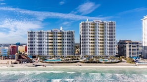 A beachfront hotel with multiple high-rise buildings, a pool area, and a beach.