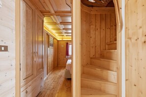 A wooden interior with a staircase leading to a bedroom.