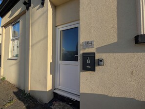 Eine Gebäudefassade mit einer Tür, einem Fenster und einem Briefkasten.