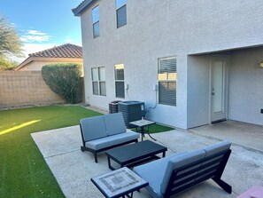 A residential backyard with a patio area featuring a sofa, a table, and a bench. - Prime North Scottsdale Retreat Near Golf, Hiking, Shops, Dining & Loop 101 (Scottsdale)