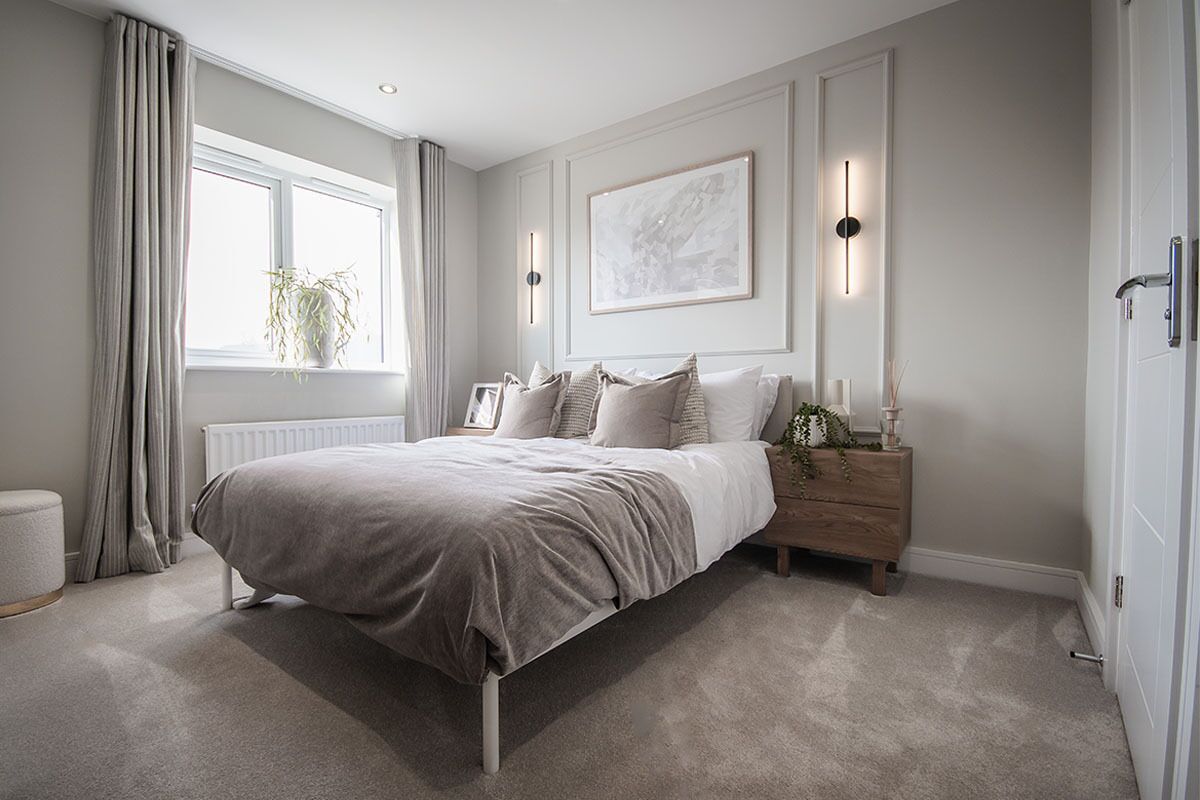 A bedroom with a bed, bedside table, lamp, and a window with curtains.