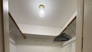 A small, enclosed room with a ceiling fan, a wall-mounted fan, and a light fixture. - Oasis at Eagle Mountain Lake (Azle)