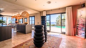 A modern kitchen with a bar area, large windows, and a view of the outdoors.