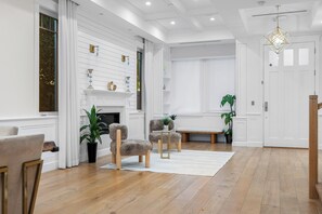Ein geräumiges Wohnzimmer mit Kamin, Holzboden und einer Bank.