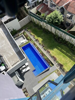 A residential area with a swimming pool, a fenced yard, and adjacent houses. - Modern 1-bedroom apartment in wonderful San Salvador with Pool & Gym (San Salvador)