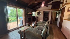 A cozy living room with a fireplace, a sofa set, and a dining area. - Serene 2-Bedroom Lakeview Cabin Retreat w/ Dock, Kayak & SUP with AC (Central City)