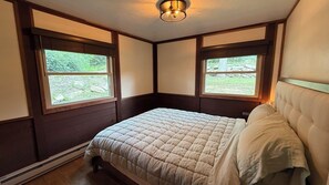 A bedroom with a bed, two windows, and a ceiling light fixture. - Serene 2-Bedroom Lakeview Cabin Retreat w/ Dock, Kayak & SUP with AC (Central City)