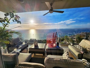 A balcony with a view of the sea, furnished with sofas and a table. - EXCLUSIVE GATED LUXURY • PANORAMIC OCEAN & SUNSET VIEWS • PRIME PV (Puerto Vallarta)