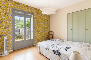 Une chambre à coucher avec un lit, une fenêtre, un radiateur et une armoire.