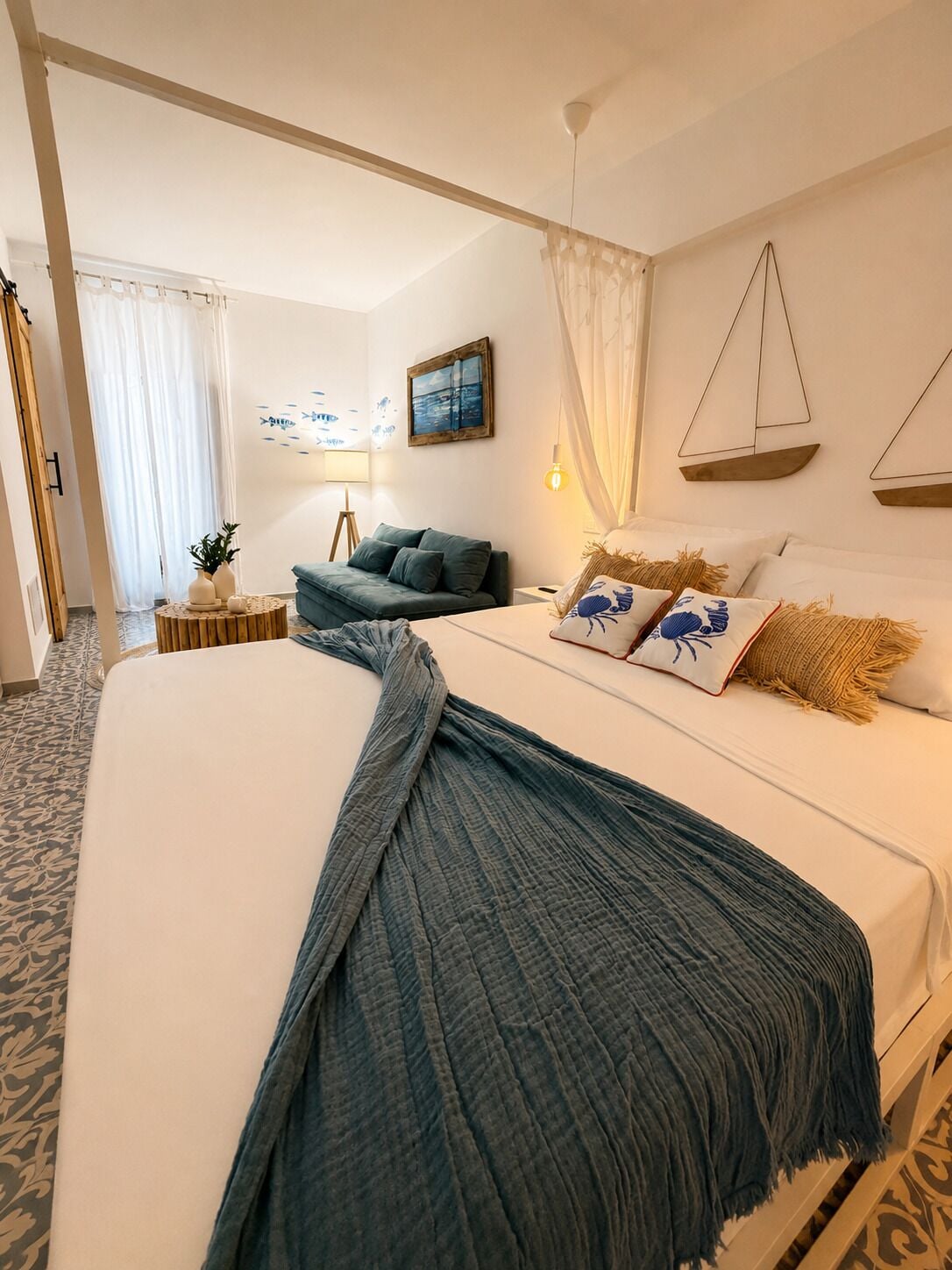 A hotel room with a large bed, a sofa, a small table, and a wall-mounted scale.