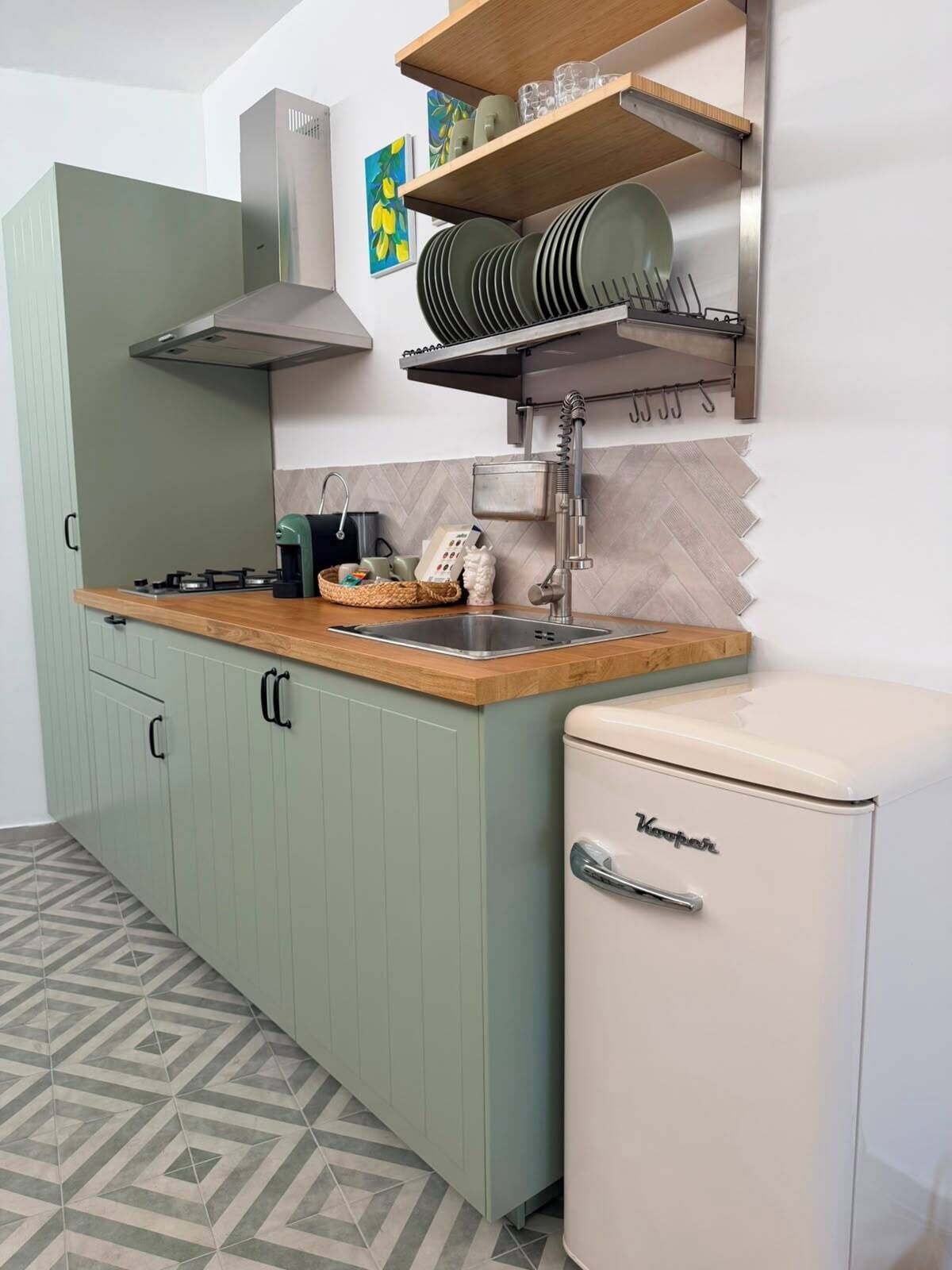 A compact kitchen with a built-in refrigerator, a sink, and a stove.