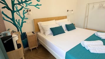 Un dormitorio con cama, mesita de noche, lámpara de pared y una obra de arte en la pared.