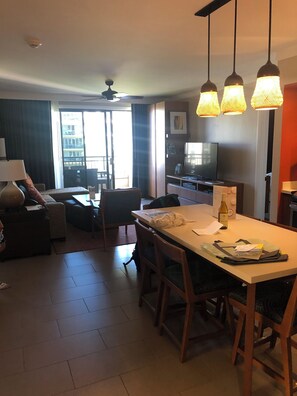 A hotel room with a dining area, a television, and a balcony with a view. - Beachfront Resort villa w/ 2 bd, 2 baths. Nov 21st -28th, 2026. Huge discount! (Lahaina)
