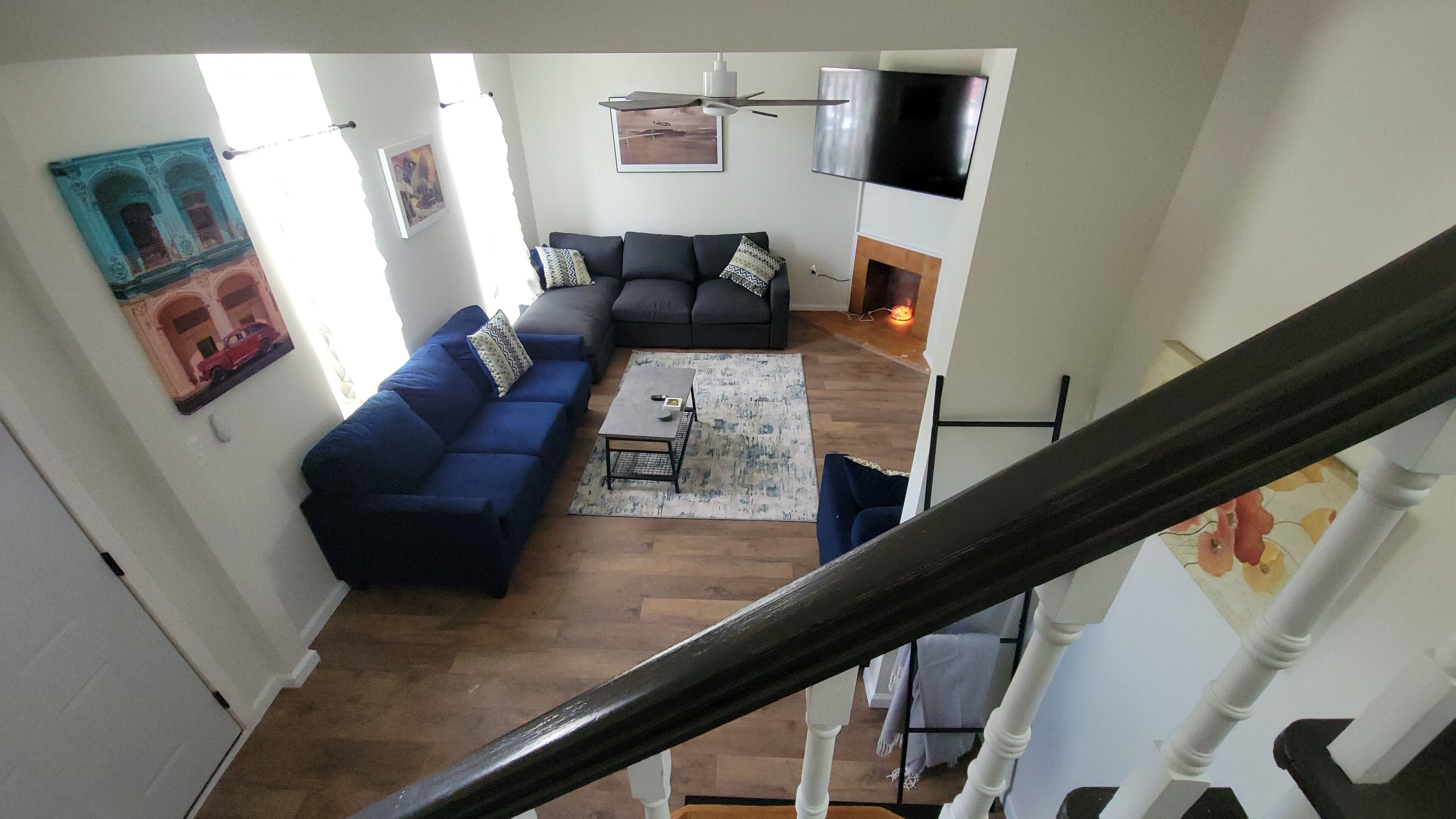 A living room with a dark blue sofa, a coffee table, and a fireplace.